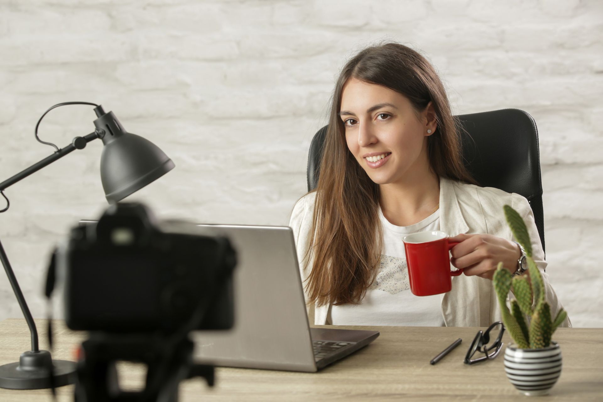 Successful businesswoman or coach recording a video for her vlog in the office
